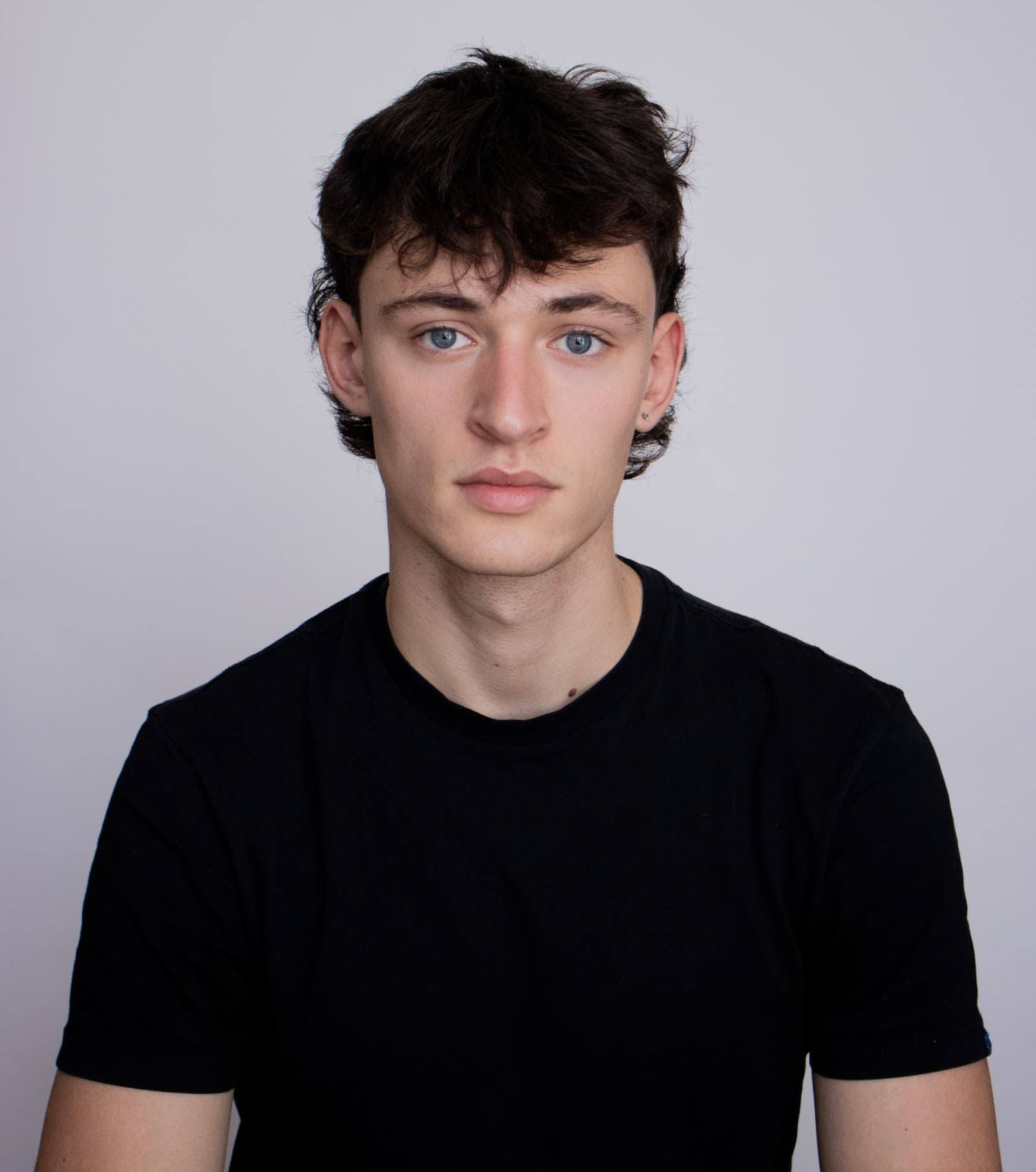 Studio headshot of Luca Stancheris against a pale grey background.